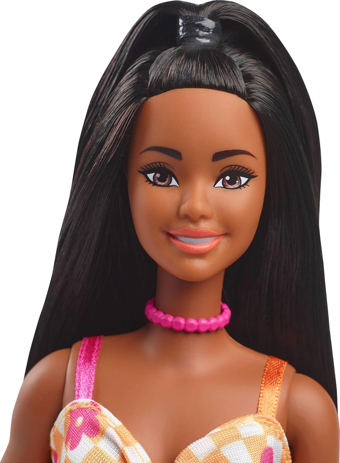 Păpușa Barbie Fashionistas nr. 233 cu păr negru, rochie midi portocalie în carouri cu flori roz, colier și sandale, HYT91