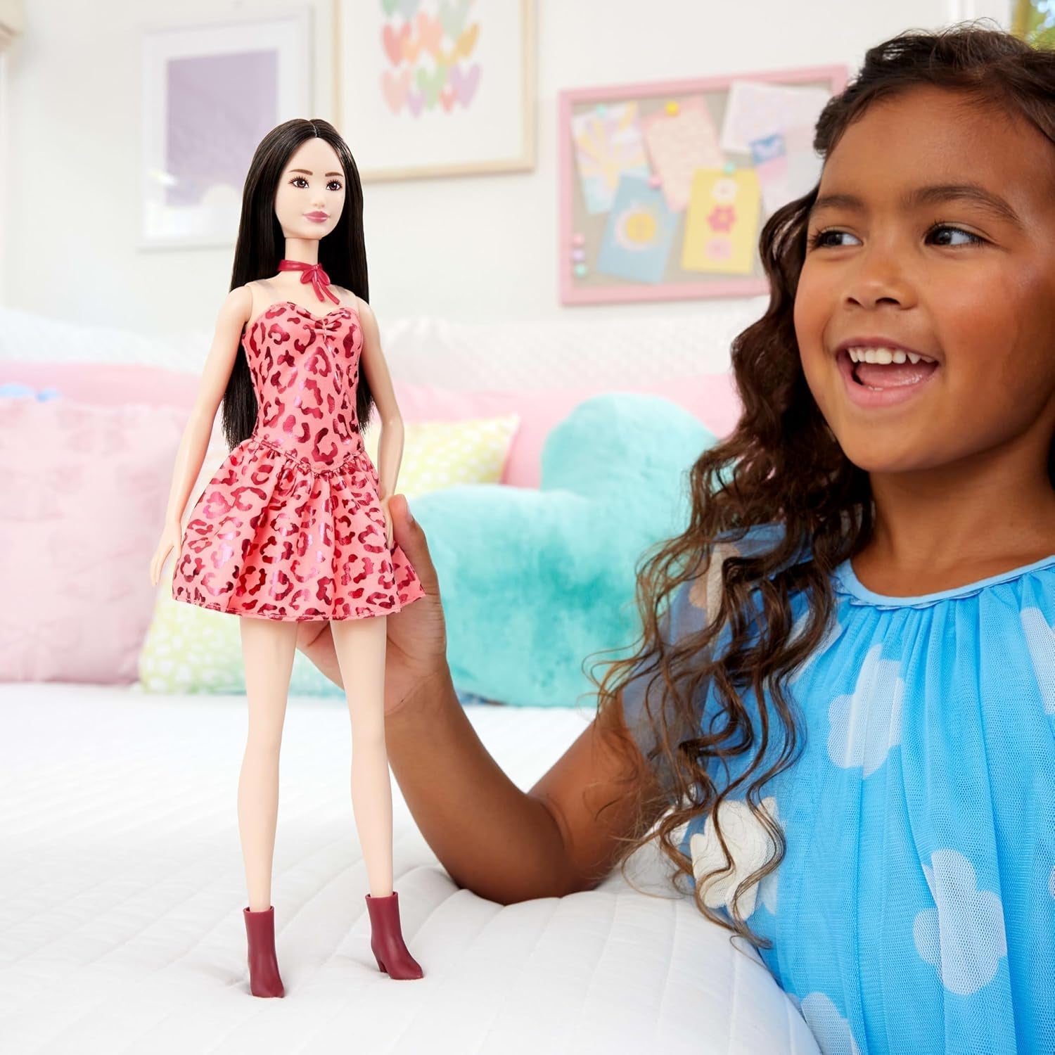 Păpușa Barbie Fashionistas nr. 246 într-o rochie roz, fără bretele, cu imprimeu leopard, cu păr negru și accesorii precum un colier cu fundă și cizme, JJN59